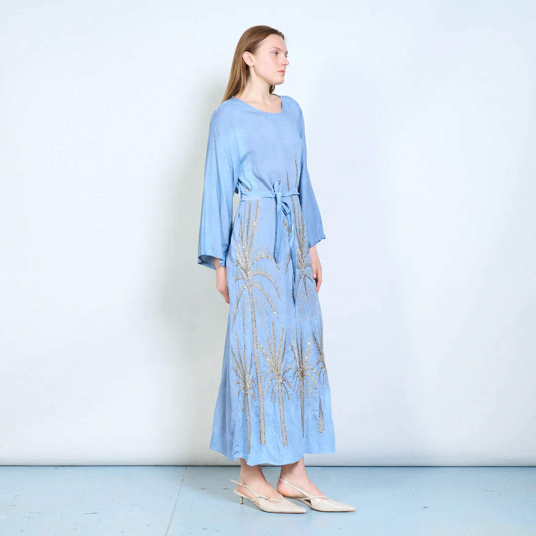 Abito lungo con maniche ampie, cintura e ricami decorativi