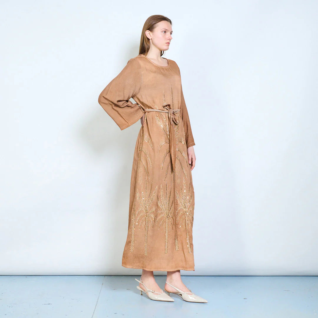 Abito lungo con maniche ampie, cintura e ricami decorativi